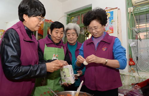 12月5日，宋秀岩在北京市东四八条社区参加_邻里守望．姐妹相助_巾帼主题志愿者服务活动时，帮助患病独居老人宋永兰做午饭包饺子。记者 杨睿摄