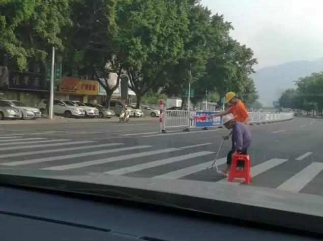 市民拍下街头暖心一幕，两志愿者接力护送老人通过斑马线。市民梁先生 摄 