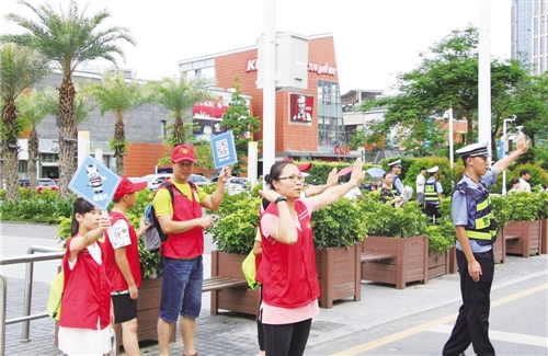 “两岸义工联盟”志愿者在引导市民文明过马路。 经济日报记者 薛志伟摄